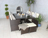 Brown rattan dining set with cream cushions and glass table, arranged with breakfast setting indoors