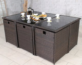 Brown rattan garden dining set with glass top table and matching cube chairs arranged indoors
