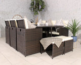 Brown rattan garden dining set with cream cushions and glass table, arranged indoors