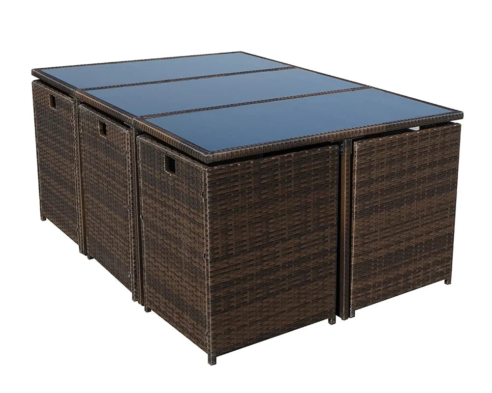 Brown rattan outdoor dining table with glass top and cube storage stools underneath