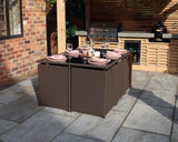 Brown rattan garden dining set with glass top table and six seats, set for outdoor meal