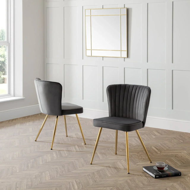 Grey velvet dining chairs with gold legs in a modern room with panelled wall and mirror