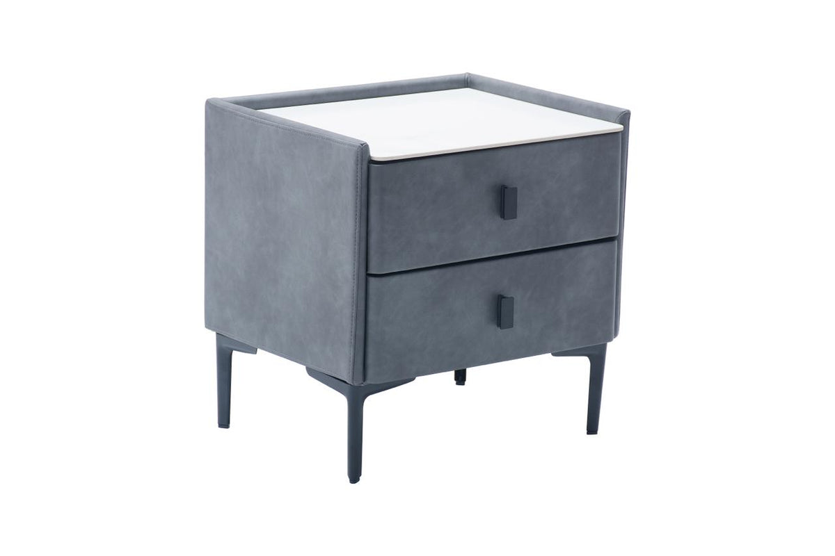 A modern two-drawer nightstand with a dark gray velvet upholstered frame, a white top surface, and slim dark legs, shown on a plain white background.