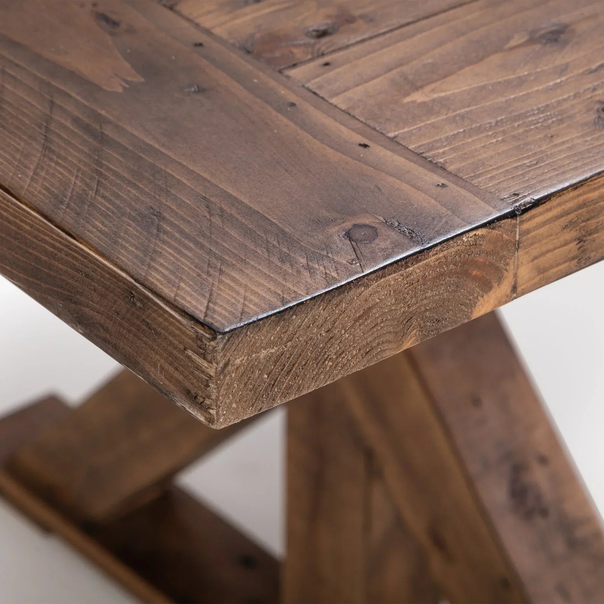 Solid wood extending dining table corner with visible grain and sturdy leg design