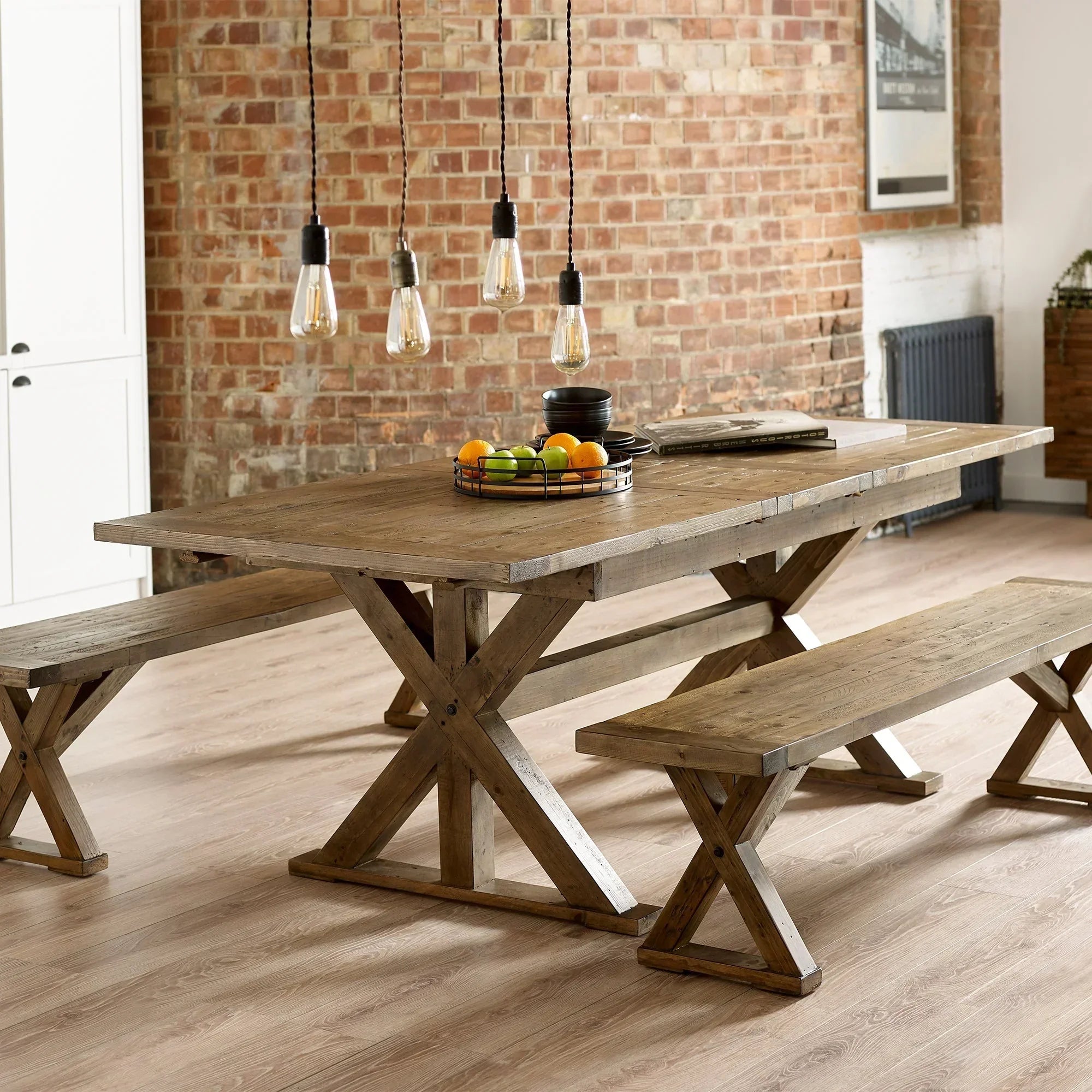Chatsworth extending dining table with benches in rustic wood finish, set in loft dining room