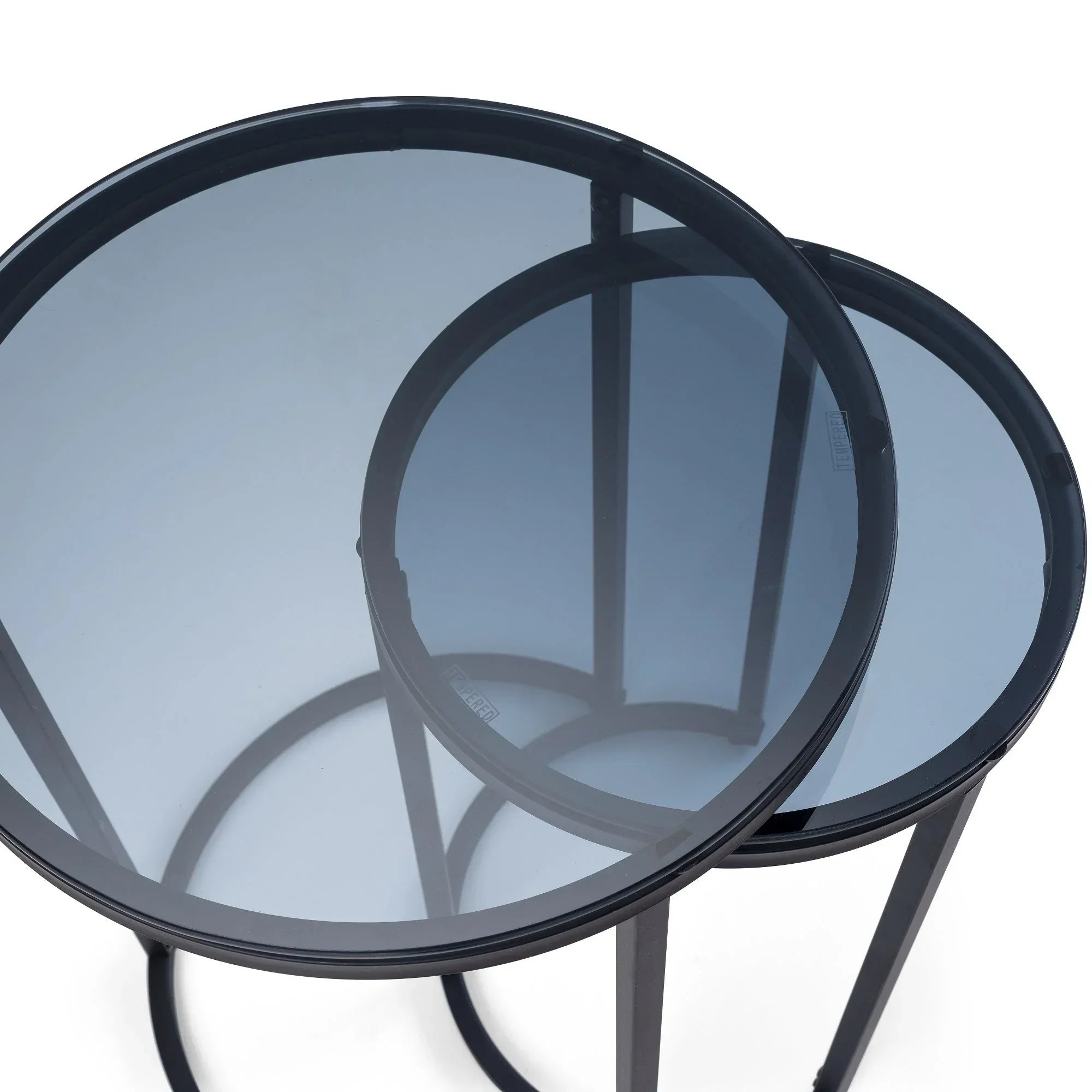 Round nesting side tables with black metal frames and tinted glass tops, top view