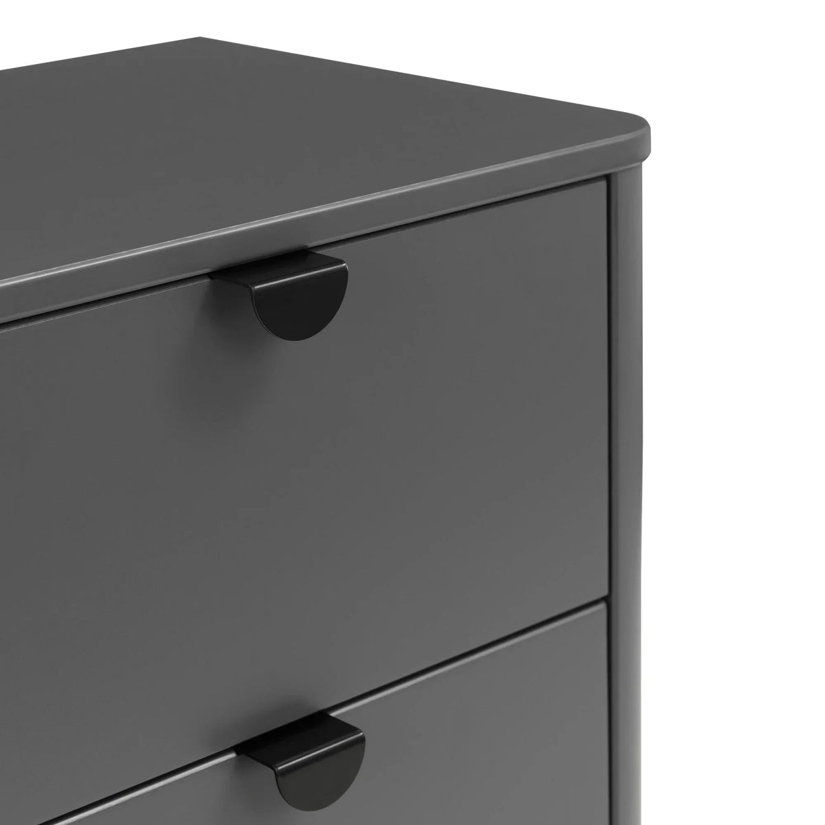 Grey chest of drawers with matte black metal handles, close-up corner view