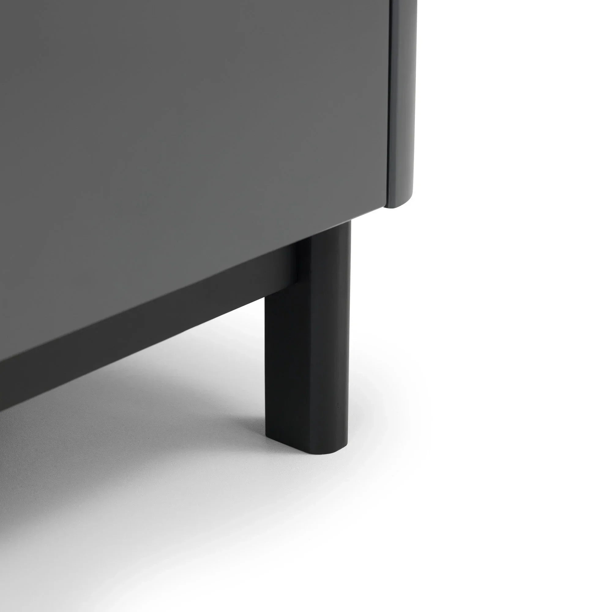 Close-up of grey cabinet leg with matte black metal finish on white floor
