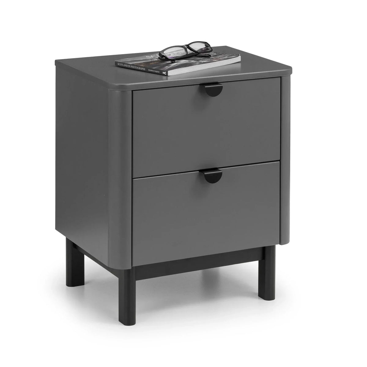 Grey bedside cabinet with two drawers and black legs, book and glasses on top