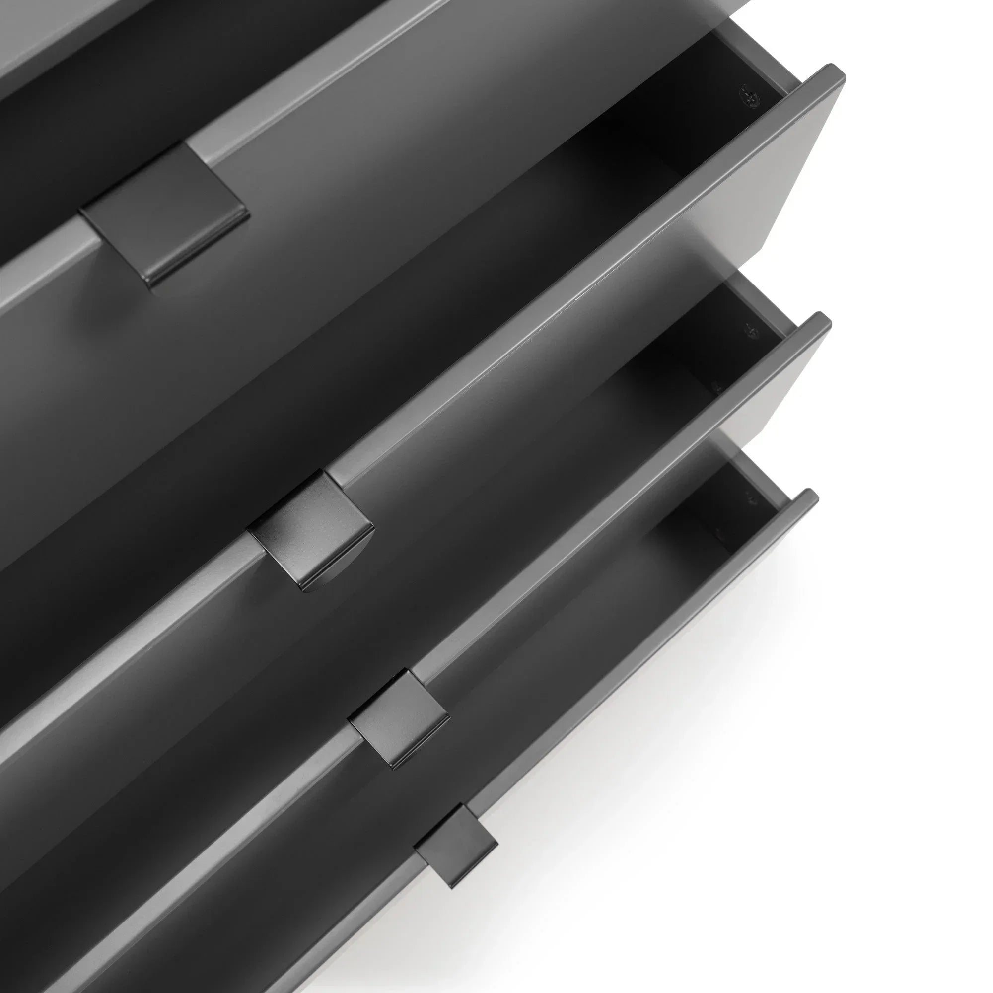 Close-up of black metal drawer handles and sleek linear cabinet design