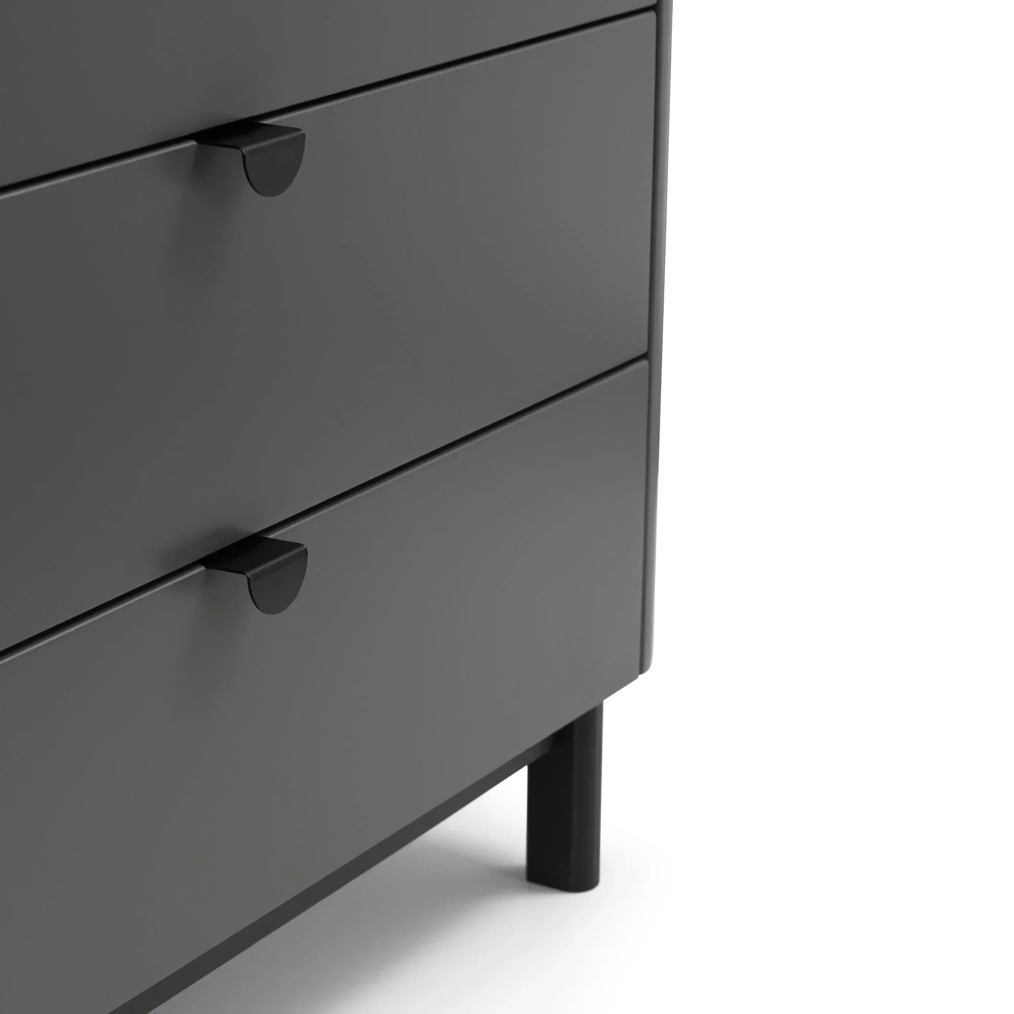 Close-up of black chest of drawers with matte finish and modern metal handles