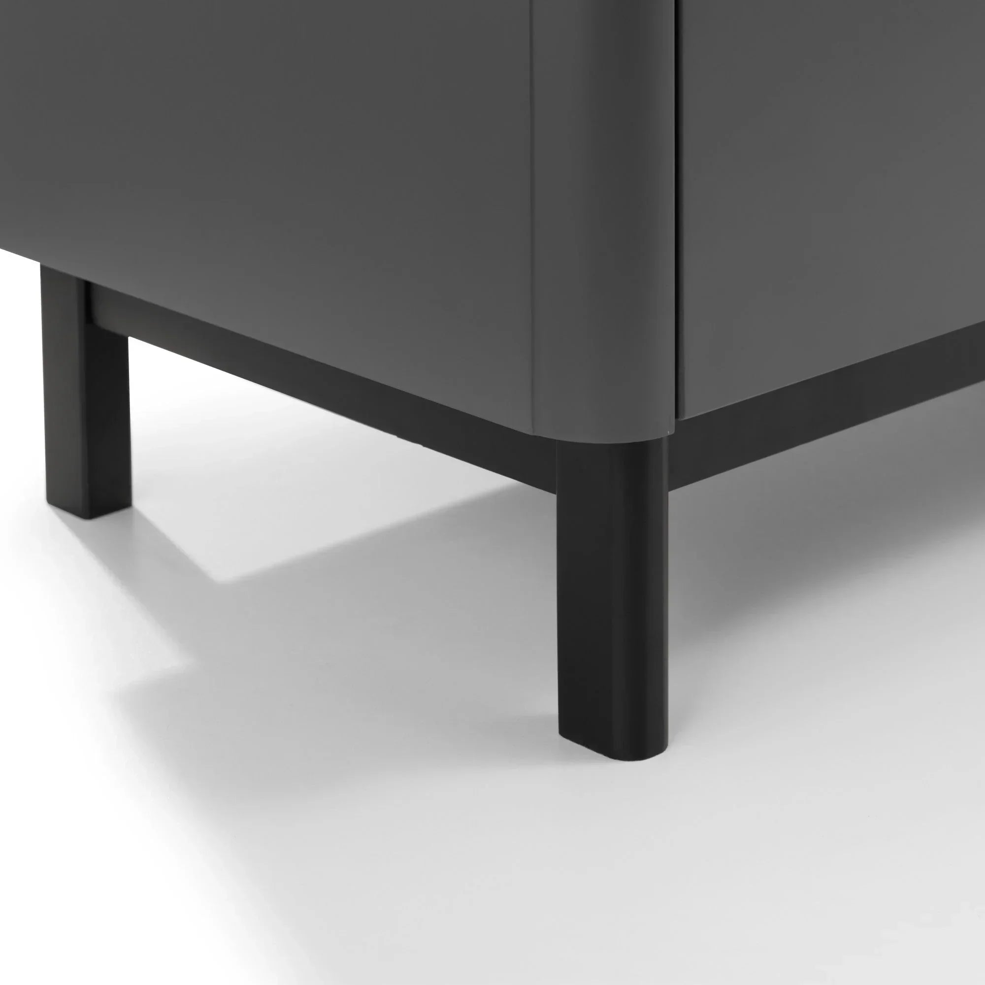 Close-up of black metal furniture legs and corner panel on grey cabinet