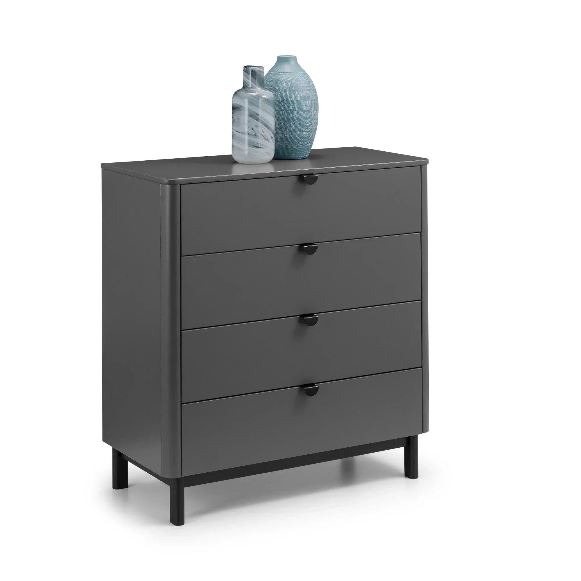 Grey chest of drawers with four drawers, black handles, vases on top, angled view