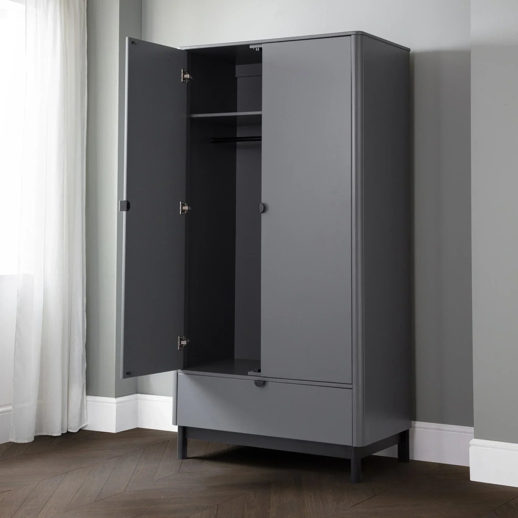 Grey wardrobe with open doors, shelf, hanging rail, and lower drawer in modern bedroom