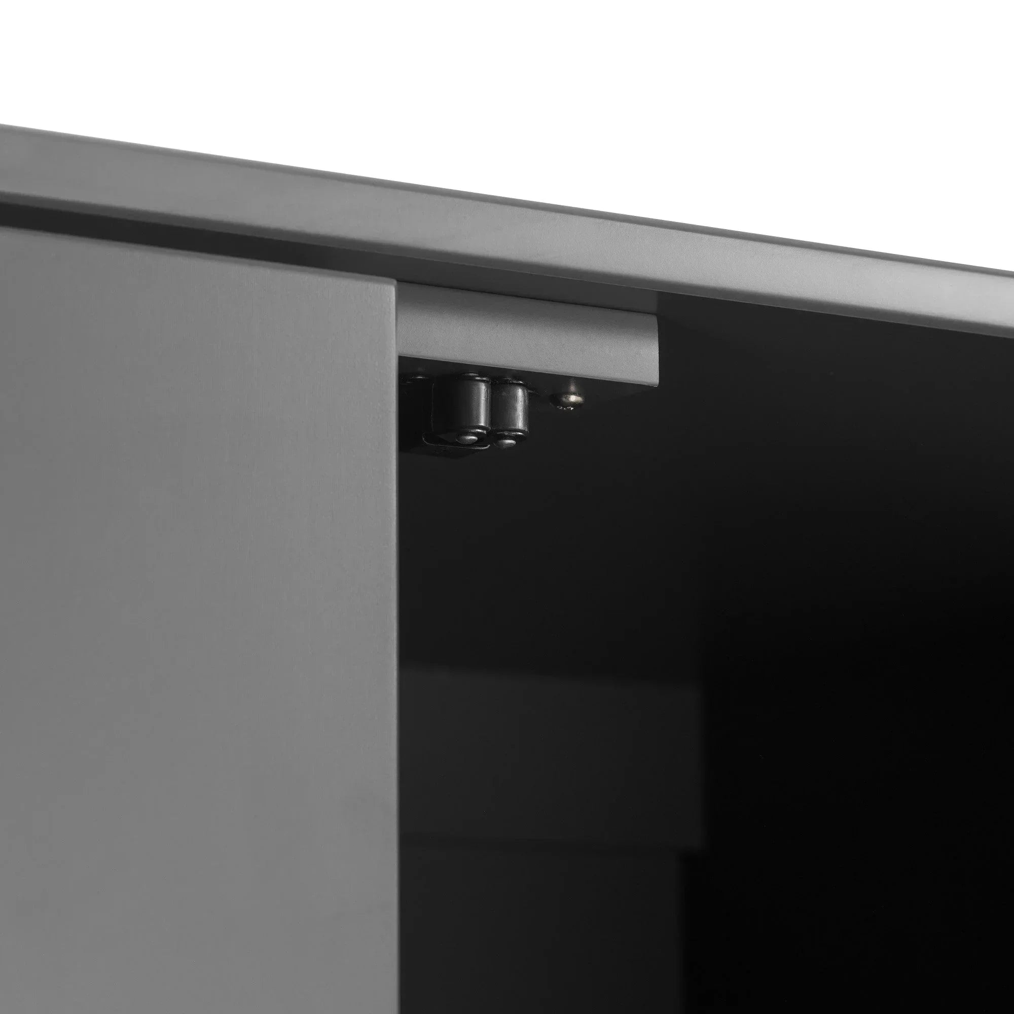 Closeup of soft-close cabinet hinge mechanism on matte grey furniture door
