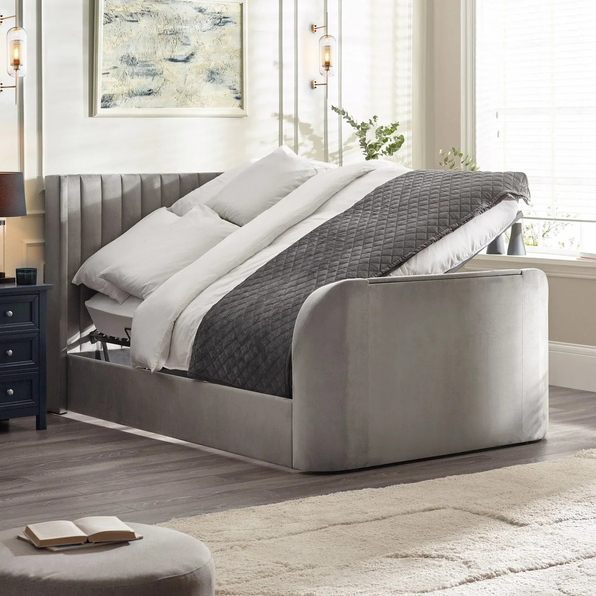 Grey upholstered ottoman storage bed with lifted mattress in modern bedroom