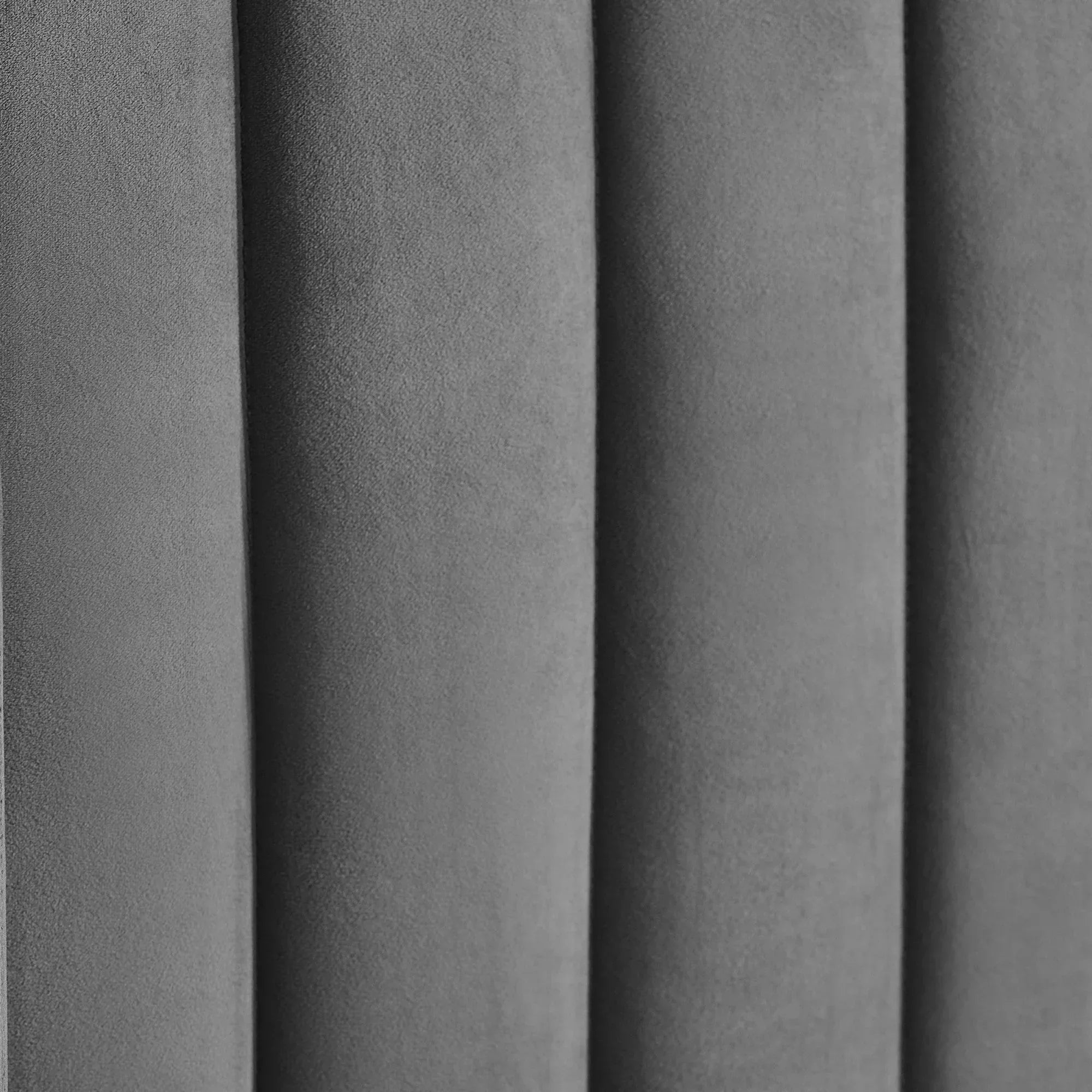 Upholstered grey fabric bed headboard with vertical panel design closeup