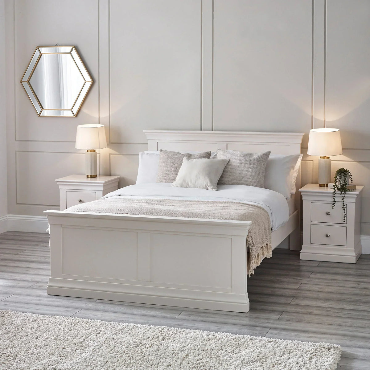 White double bed with matching bedside tables, lamps, and neutral bedding in modern bedroom