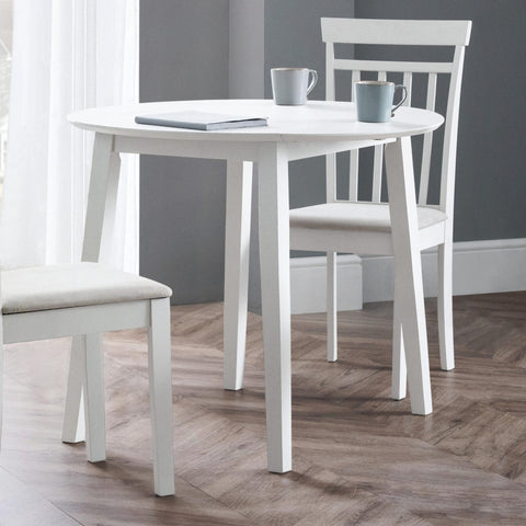 White round Coast dropleaf table with one leaf dropped, two white chairs, wood floor, grey walls