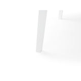 Close-up of white table tapered legs and rounded edge on white background.