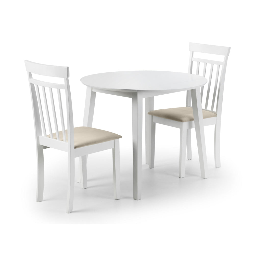 Two white wooden chairs with beige cushions placed at a round white dining table.