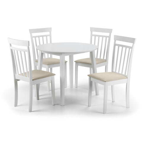 Round white dining table surrounded by four white wooden chairs with beige cushions.