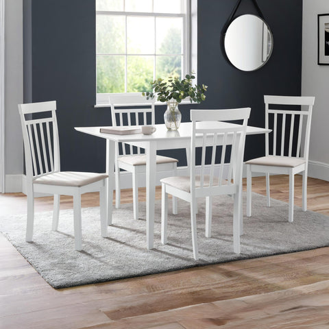 Set of four white wooden dining chairs with beige seats around white table in bright room