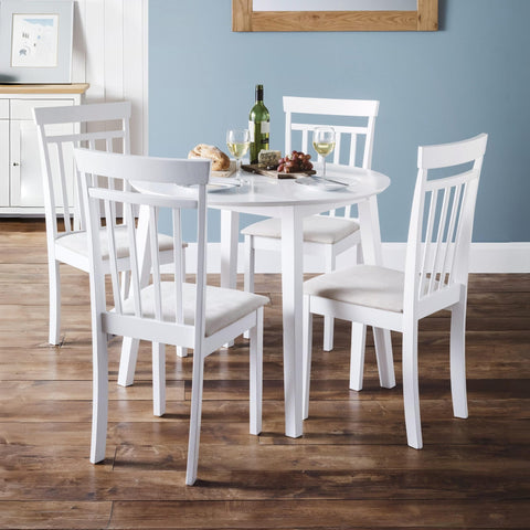 Set of four white wooden dining chairs with vertical slats and cushioned seats around a white round table