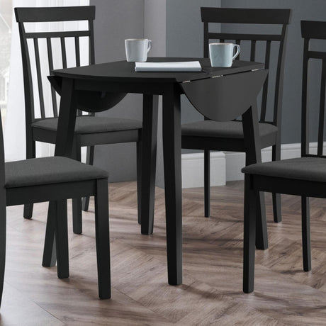 Black drop-leaf table with two matching chairs in a room with wood flooring and gray walls