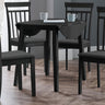 Black drop-leaf table with two matching chairs in a room with wood flooring and gray walls