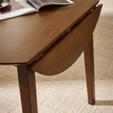 Close-up of brown wooden round table with one drop leaf folded down showing leg and hinge detail