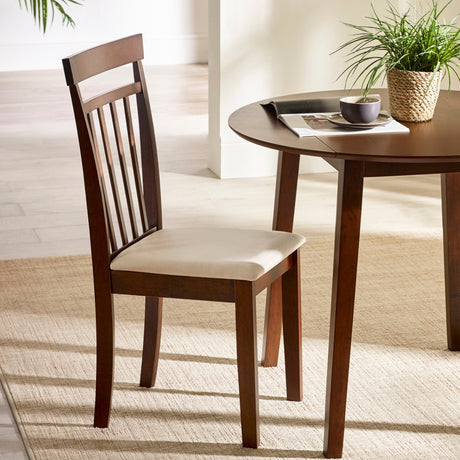 Single brown wooden dining chair with beige cushioned seat beside round wooden table in bright room