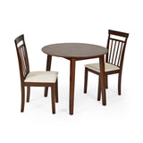 Two dark wood dining chairs with beige cushions positioned around small round dark wood dining table