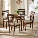Two dark wood chairs with beige cushions with round dark wood dining table under glass pendant in bright room