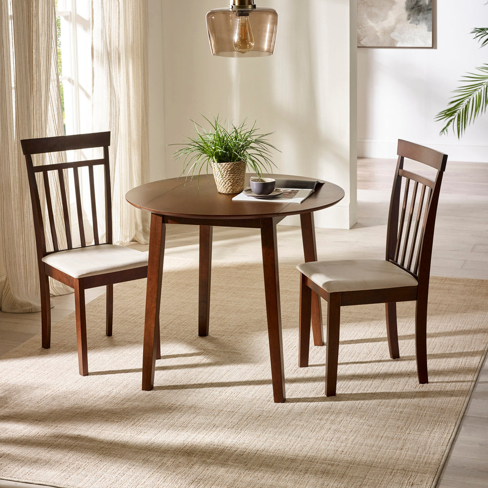 Round dark wood dining table with two matching chairs with beige cushions in bright room with rug