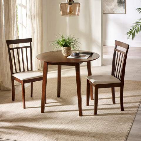 Round dark wood dining table with two matching chairs with beige cushions in bright room with rug