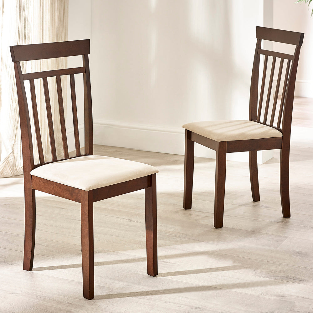 Two brown wooden dining chairs with beige cushioned seats in bright room on light wood flooring