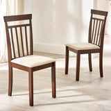 Two brown wooden dining chairs with beige cushioned seats in bright room on light wood flooring