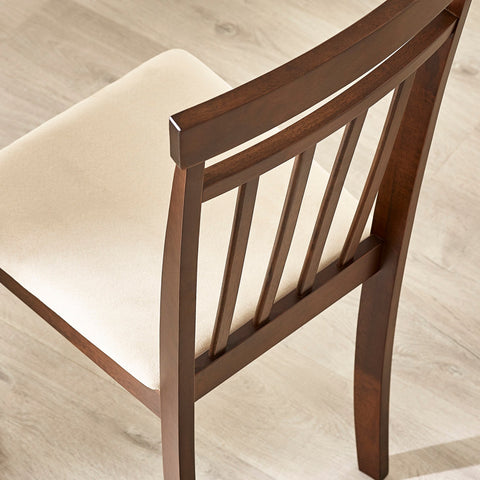 Close-up rear angle of brown wooden dining chair showing slatted backrest and beige cushioned seat