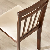Close-up rear angle of brown wooden dining chair showing slatted backrest and beige cushioned seat