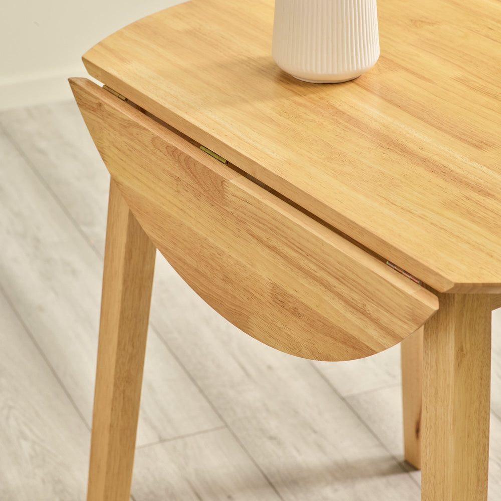 Close-up of natural wood table edge and hinge mechanism showing leaf folded down