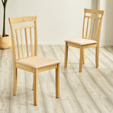 Two light wood dining chairs with beige cushions positioned on gray wood floor in bright room