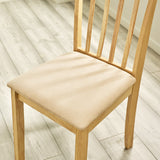Close-up of beige cushioned seat and wooden frame of dining chair on light wood floor