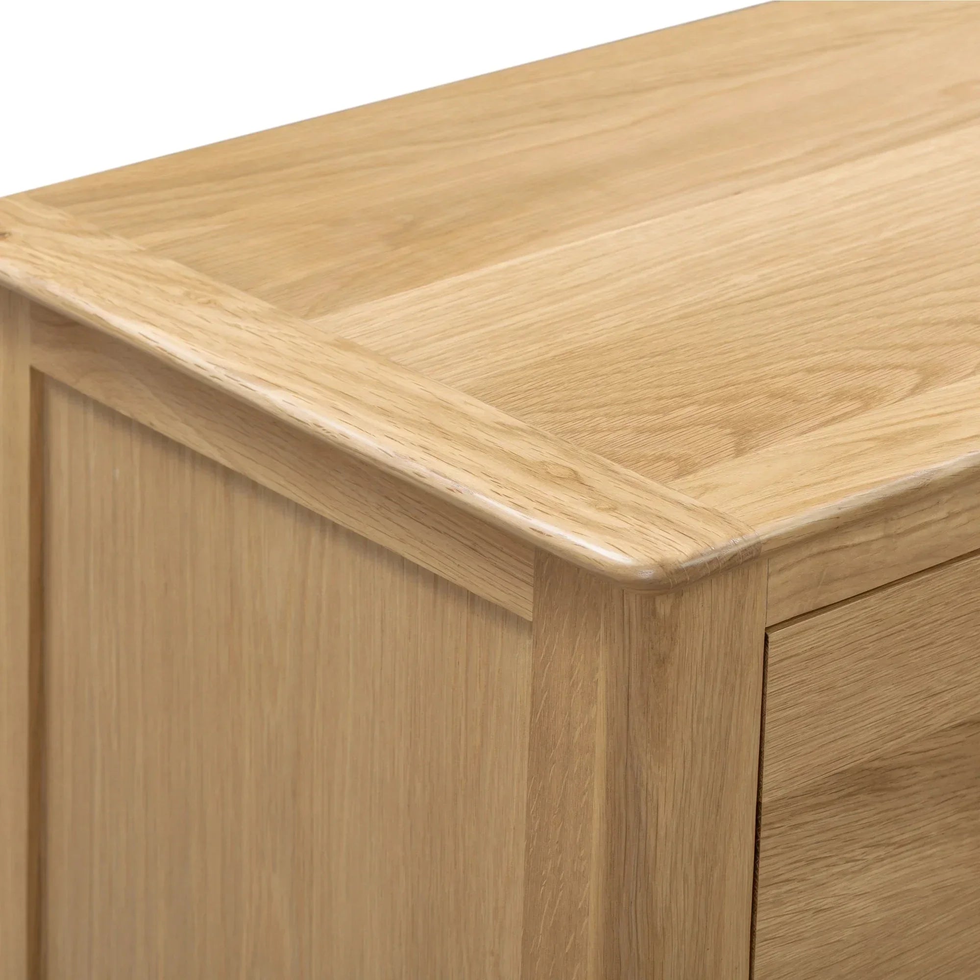 Closeup of natural oak two drawer chest corner showing wood grain and panel detail