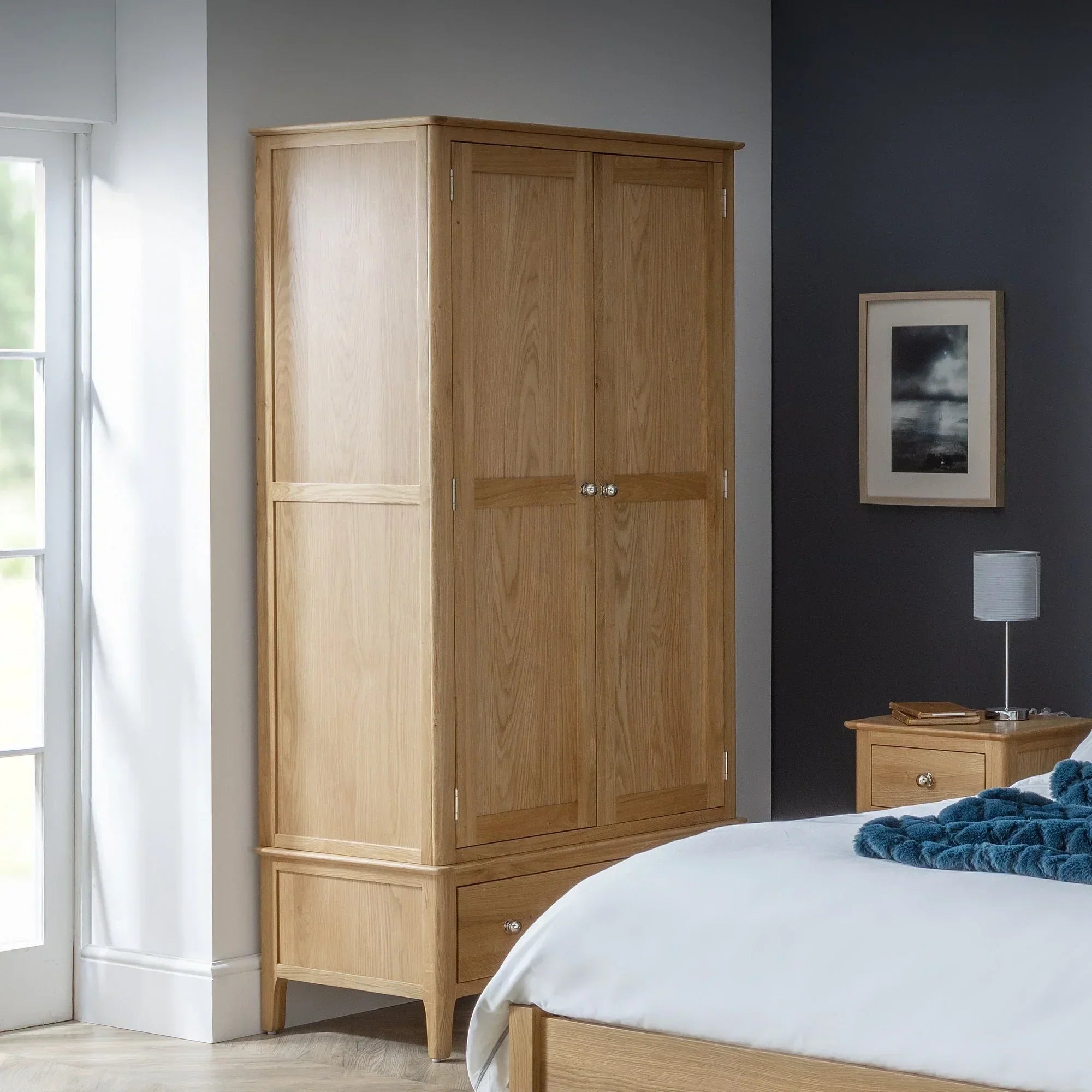Oak 2 door 1 drawer wardrobe in modern bedroom next to window and bedside table