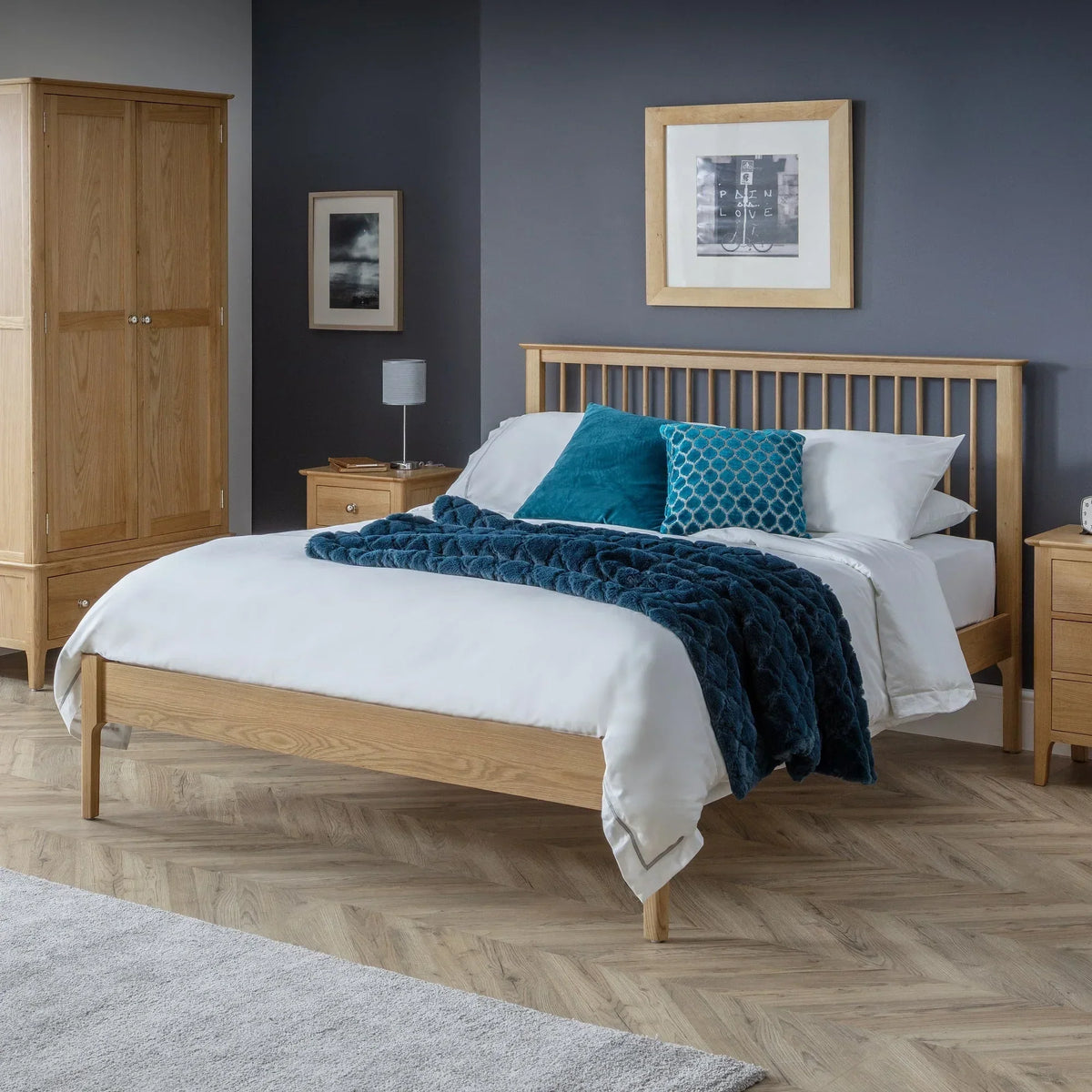 Oak double bed with slatted headboard, white bedding, and blue cushions in modern bedroom