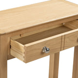 Oak console table close-up showing open drawer with silver knob and wood grain finish