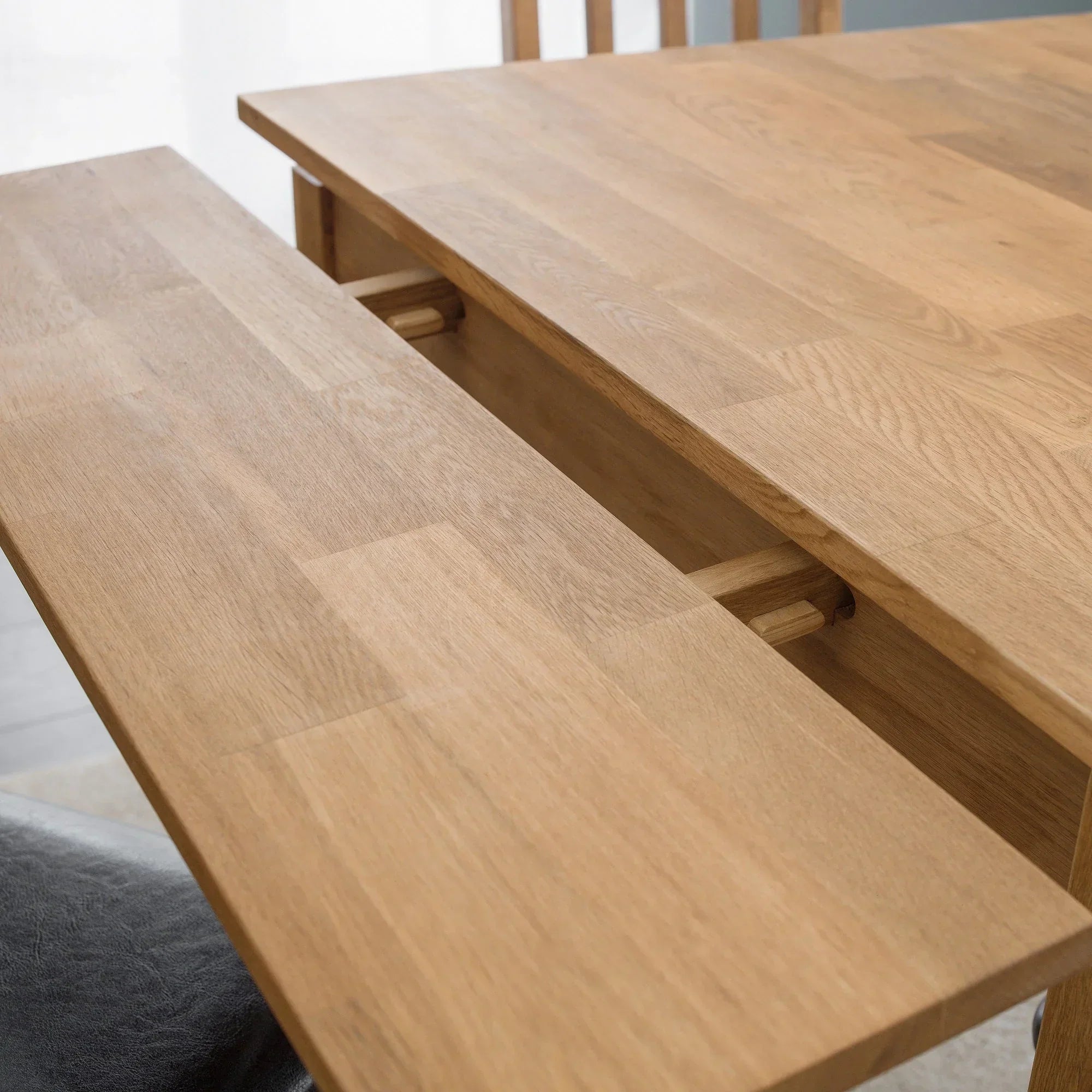 Oak extending dining table with slide-out extension leaf detail