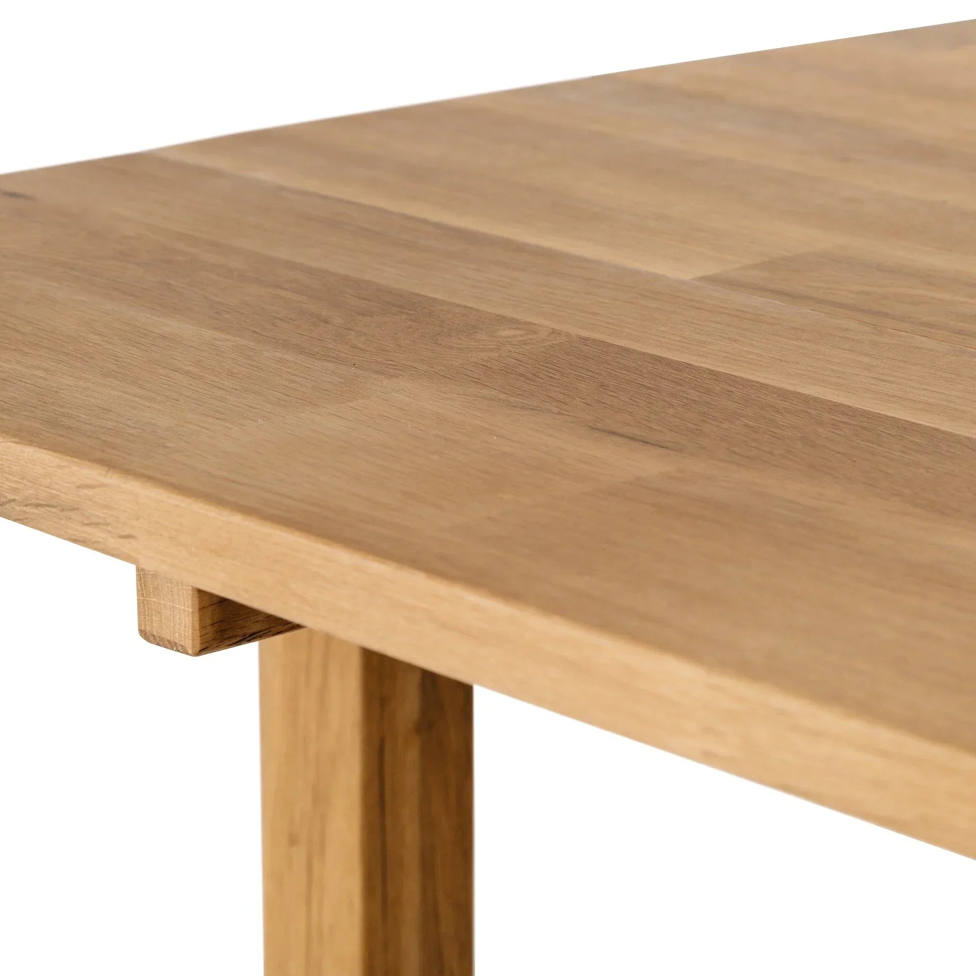 Oak extending dining table corner with visible grain and natural wood finish
