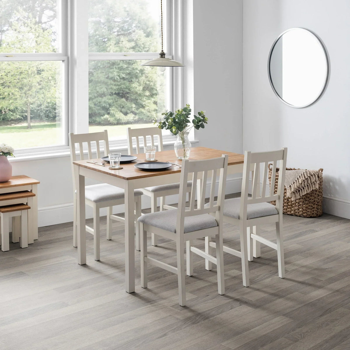 Ivory wooden dining chairs with grey cushions around a rectangular oak dining table in bright room